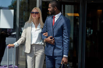 affable hotel clerk serve business client, confident and polite black man in formal wear help lady to reach the car with convenience