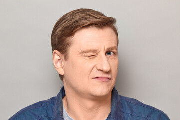 Fototapeta premium Portrait of charismatic blond mature man winking at you