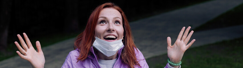 Redhead girl pulls down medicine mask and feels happy after covid quarantine end