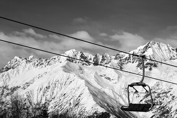 Chair-lift in snow winter mountains at nice sunny day