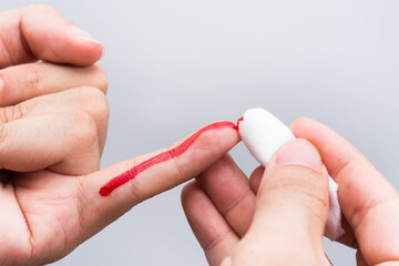 Use a cotton wool to wipe the blood at the wound on fingertips that are bleeding.