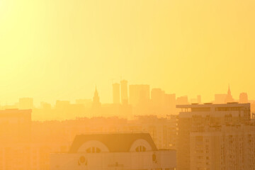 Cityscape of Moscow city in Russia during golden sunset. Small haze in the air. Silhouettes of buildings are visible in the background. Golden hour theme.