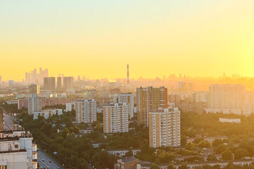 Cityscape of Moscow city in Russia during golden sunset. Small haze in the air. Blurred Moscow International Business Center in the background. Golden hour theme.