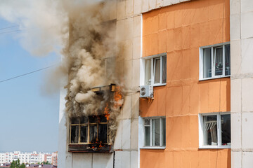 fire on the balcony of a multi-storey building, black clouds of smoke, apartment smoke,...