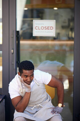 sad cafe owner sit outdoors, his cafe restaurant is closed, has no clients due to coronavirus pandemic, crisis concept