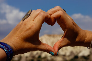 Symbol of heart made up of womens fingers through it is seen Cappadocia
