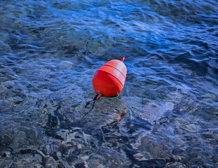 Orange Buoy. Isolated.Orange nautical  buoy object  floating in blue waters. Stock Image.