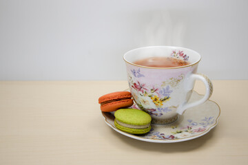 Colorful macaroons and a cup of tea. Afternoon tea break, traditional french sweet.