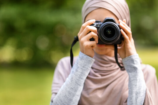 Closeup of muslim woman photographer taking photos