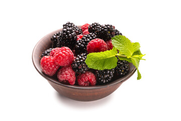Raspberry, blackberry and mint leaf in ceramic brown bowl isolated on white