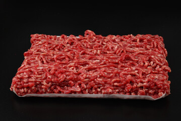 Chopped raw meat  on a black  background.