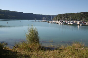 Sail boats harbor on a turquoise lake