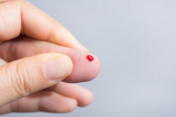 Blood drop on fingertip prepare for checking the glucose level with a glucometer for examining diabetes mellitus.