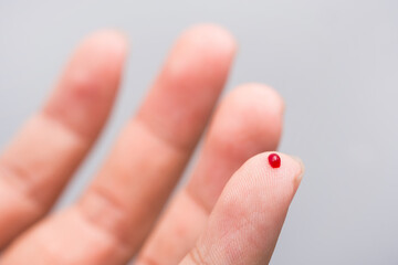 Blood drop on fingertip prepare for checking the glucose level with a glucometer for examining diabetes mellitus.