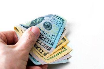 A man's hand with money of more than a hundred dollars isolated on a white background, a bribe, payment.
