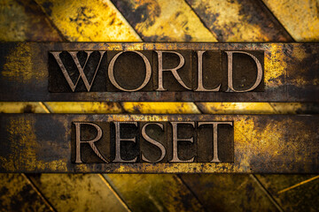 World Reset text formed with real authentic typeset letters on vintage textured silver grunge copper and gold background