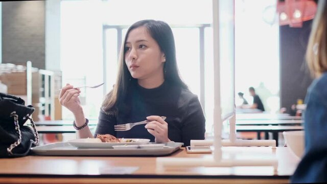Asian woman sitting separated in restaurant eating food .keep social distance for protect infection from coronavirus covid-19, restaurant and social distancing concept.4k footage.