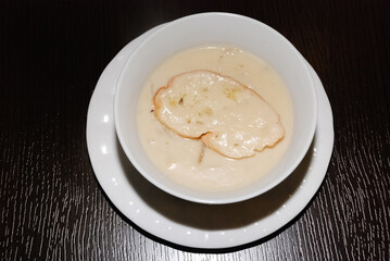 shiny creamy mushroom soup in the white bowl