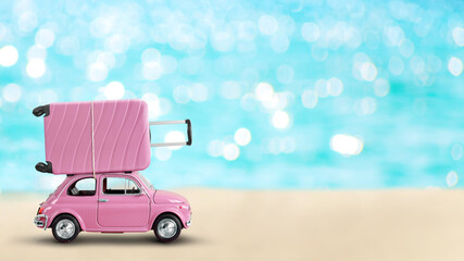 Pink toy retro car with pink suitcase on a roof on blue turquoise sea background