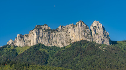 Fototapeta na wymiar Annecy in France, the cliffs on the lake in summer, with paragliding 