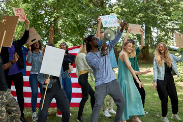 american youth holding a sign protesting the laws against marijuana usage. outdoors. activists...