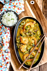 cuisine thaï : gambas au lait de coco , curry, dés de courgettes et oignons rouges avec du riz 