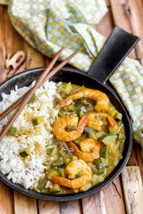 cuisine thaï : gambas au lait de coco , curry, dés de courgettes et oignons rouges avec du riz 