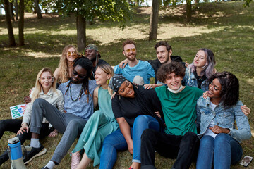 Fototapeta na wymiar portrait of friendly happy youth on grass in the park, multiethnic group of people happy together, share funny stories and hug