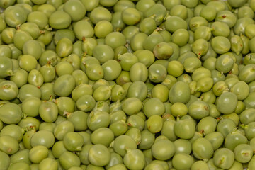 Fresh green peeled peas. The peas are sprinkled on top of each other.