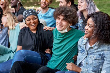happy caucasian and african american people have rest in the public park. people urge to be tolerant of each other. friendship, people relationships