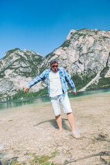 Naklejka premium man walking by lake beach mountains on background with cold water
