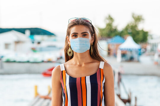 Summer vacation. Portrait of a Beautiful tanned woman in a medical mask. The concept of protection from virus and allergies