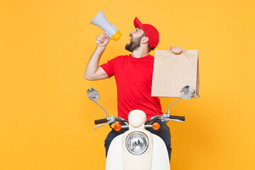 Delivery man in red cap t-shirt uniform driving moped motorbike scooter hold craft paper packet with food isolated on yellow background studio Guy employee working courier Service quarantine concept