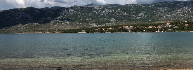 a green mountain massif above the sea in summer