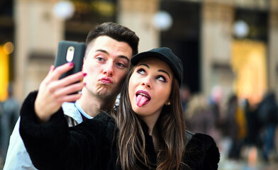 Couple of tourists taking funny selfies in Milan