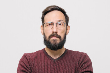 Obraz premium zamyślony młody człowiek w bordowym swetrze w studio na białym tle