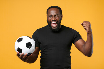 Screaming african american man guy football fan in black t-shirt isolated on yellow background....