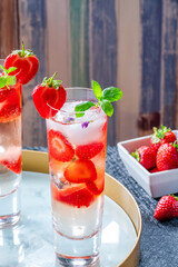 Elderflower and vodka cocktail with strawberries, tonic water and ice cubes
