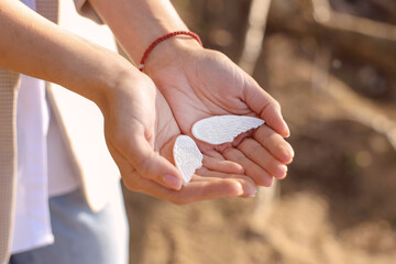 White plaster wings in the hands of a girl. concept psychology