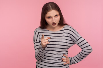 Fototapeta premium Be careful, I'm warning! Portrait of strict bossy brunette woman in striped sweatshirt giving advice, scolding with negative admonishing gesture. indoor studio shot isolated on pink background