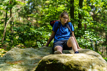 girl on an rock in a forest in blue sportswear