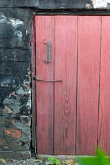 Wooden old pink doors in the wall of an old house.