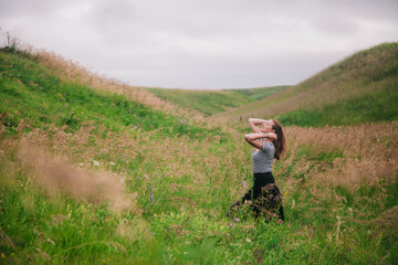 Beautiful girl in a black long skirt and striped T-shirt walks in green hole