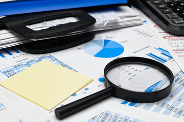 business office desk closeup - financial reports, analysis and accounting, set of documents, tables and graphs, various items for bookkeeping, calculator