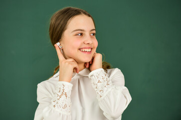 real happiness. back to school. small girl in headphones at blackboard. listening audio book. free...