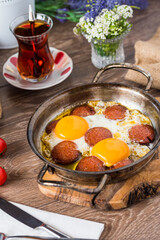 Traditional Turkish Breakfast - Fried Egg with Turkish sausage. Bread, tomato and Tea