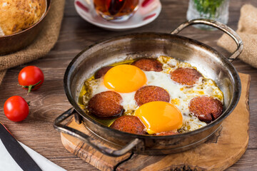 Traditional Turkish Breakfast - Fried Egg with Turkish sausage. Bread, tomato and Tea
