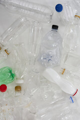 Flatlay composition with different empty plastic bottles over white background