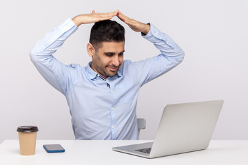 Safety insurance, secured life. Positive man agent sitting office workplace, talking with client on video call and showing house roof gesture over head. indoor studio shot isolated on white background