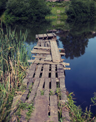 little wooden pier at the lake at summer evening